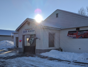 Depicts car wash with sun shining and open sign